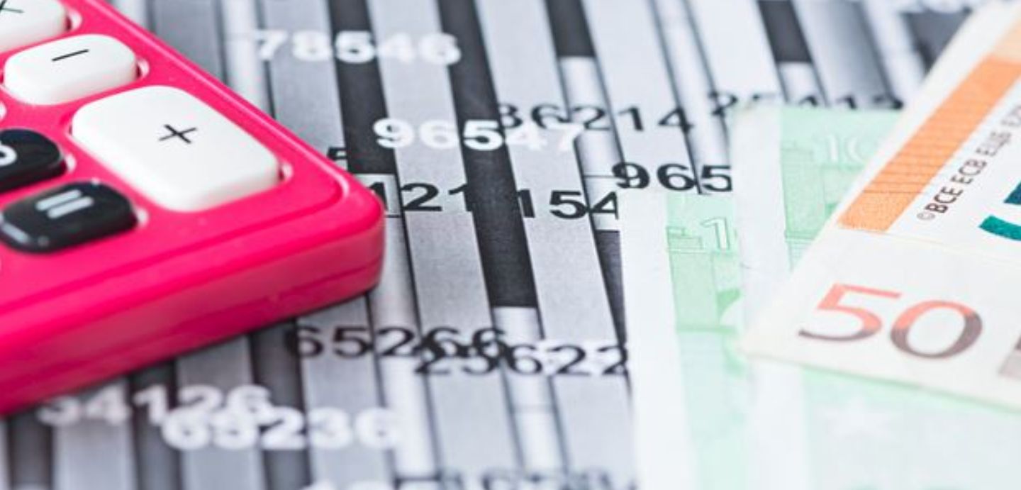 Imaxe de un documento con datos, unha calculadora e billetes de 50 euros.