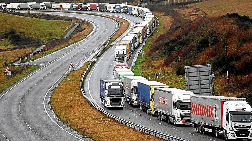 Na imaxe vese una carretera longa con curvas, donde están os camións en fila.